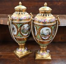 A pair of 20th century Continental gilded porcelain pot pourri urns and covers with painted reserves