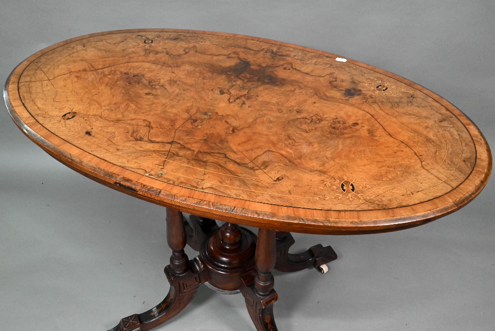 A Victorian inlaid figured walnut centre table, the oval top raised on four to swept legs, on - Image 2 of 6