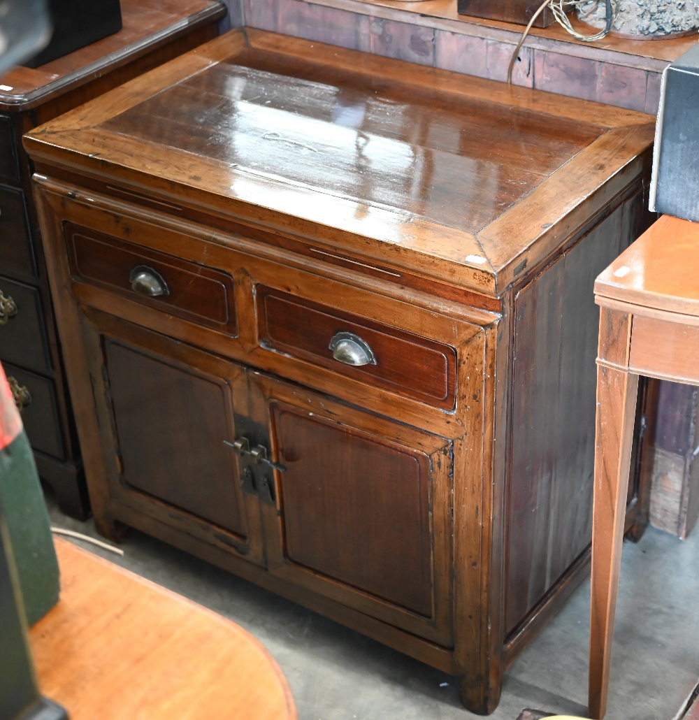 A Chinese stained and lacquered hardwood side cabinet with two drawers over panelled cupboards, 80