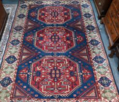 An old Turkish Caucasian design carpet  blue ground with three red ground lozenges with conforming