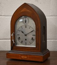 An antique German inlaid mahogany lancet-cased mantel clock with silvered dial, striking and chiming