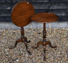 A pair of Georgian style circular mahogany tilt-top occasional tables, with turned columns and tri-
