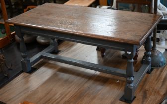 A rectangular oak coffee table on slate grey painted base with baluster turned legs united by