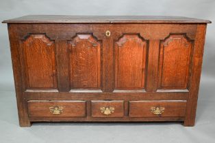 An 18th century oak mule chest, the three plank top over four fielded arched panels and three