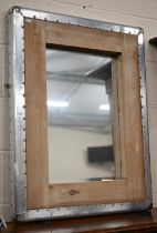 An industrial design wall mirror in hardwood and studded sheet-metal frame, 72 cm wide x 90 cm high