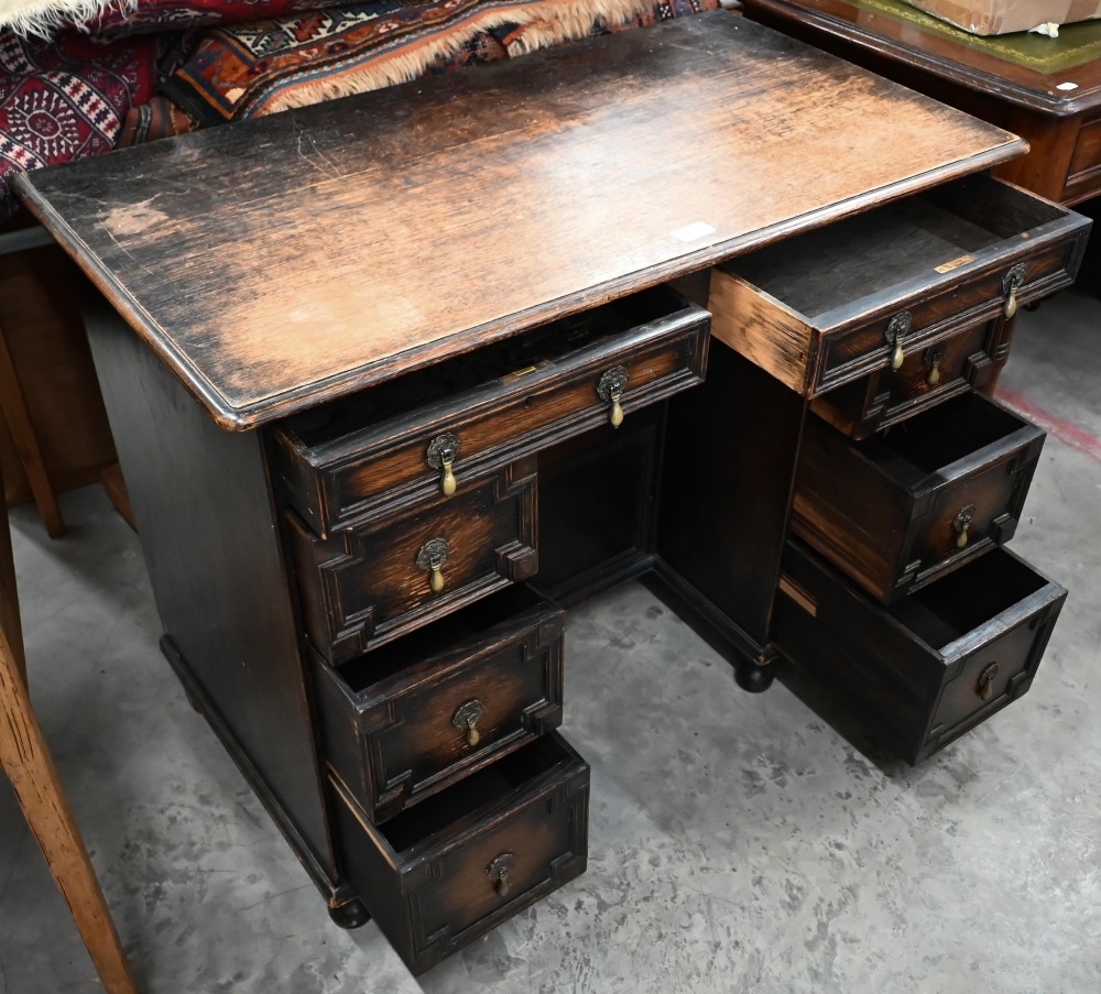 An early 20th century oak Jacobean style kneehole desk, eight drawers around central niche with - Image 2 of 4