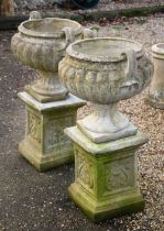 A pair of weathered garden planters raised on square plinth bases, 84 cm h o/all (2)
