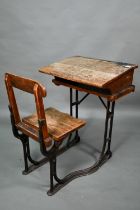 A Victorian cast iron and oak student/school desk, the slope top carved with multiple graffiti,