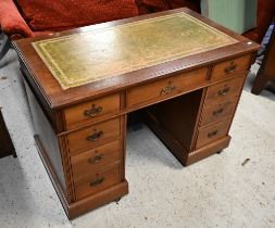 An Edwardian mahogany twin-pedestal desk with gilt-tooled green leather top and nine drawers a/f,