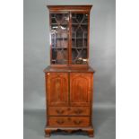 A Victorian mahogany cabinet with pair of Arabic arched panel doors over two long drawers, raised on