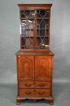 A Victorian mahogany cabinet with pair of Arabic arched panel doors over two long drawers, raised on