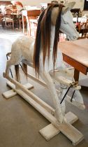 A painted wooden rocking horse on swing stand with turned supports, 140 cm wide x 124 cm high
