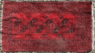 A worn Afghan gul design red ground rug, 200 x 120 cm