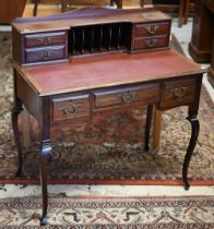 An Edwardian Carlton House style writing table, with burgundy leatherette top, raised on slender