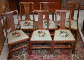 A set of six Georgian style mahogany dining side chairs, with green needlepoint floral seat pads (6)