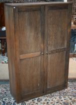 A two door oak cupboard, the interior fitted with pigeon holes and shelves, 115 cm x 40 cm x 178