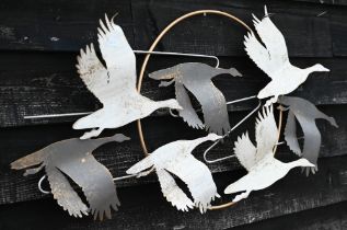 A painted metal wall-ornament, geese flying in front of the moon, 58 x 106 cm