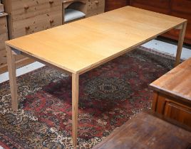 A modern blonde wood extending dining table, the centre leaf housed within the frame, raised on