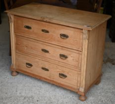 A continental pine three drawer chest, raised on ball feet, 111 cm x 55 cm x 86 cm h