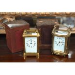 Two vintage brass carriage clocks in leather travel cases