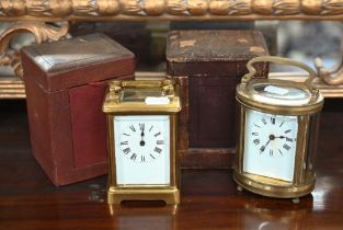 Two vintage brass carriage clocks in leather travel cases