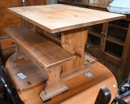 A pine refectory dining table, raised on shaped trestle ends united by a centre stretcher, 122 cm