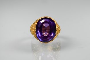 A 1970s yellow metal ring of sculptural design inset with oval amethyst, size O, stamped k18, approx