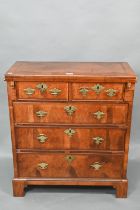 An 18th century feather-banded walnut bachelors chest, the fold over top over two short and three