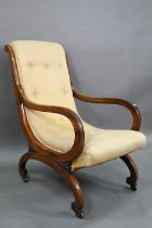 A George III rosewood hoop armchair with scroll back button upholstery, raised on brass castors