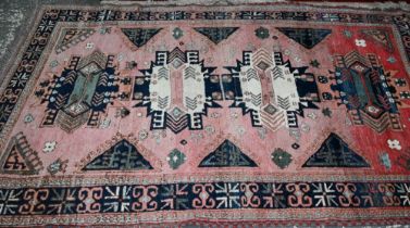 A mid-century Turkish rug, faded red ground rug with geometric design, 228 cm x 164 cm