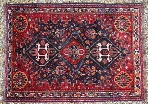 A Persian Shiraz rug, the triple lozenge design on blue-brown ground, 162 cm x 116 cm