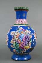 A Chinese famille rose blue ground vase decorated in high-relief with a dragon flying over various