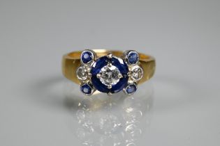 An sapphire and diamond cluster ring, the central round brilliant cut diamond surrounded by four