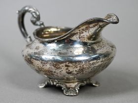 A heavy quality William IV silver milk jug of compressed form with scroll handle and shell and