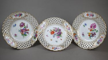Three Meissen cabinet plates, painted with floral sprays and insects within basket-weave pierced