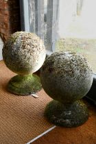 A large pair of weathered old cast stone ball finials, 37 cm dia. raised on circular socle bases, 50