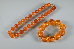 A row of circular amber beads double knotted throughout, approx 40g all in to/w a faux amber bead