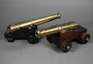 A 19th century brass model cannon with 26 cm brass barrel on wooden carriage, to/w another, later