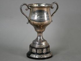A two-handled silver trophy cup on stemmed foot, London 1922, 9.2oz, 18cm high, on ebonised plinth