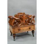 A late Victorian walnut Canterbury, the four moulded and fret cut divisions over a base drawer, on