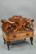 A late Victorian walnut Canterbury, the four moulded and fret cut divisions over a base drawer, on