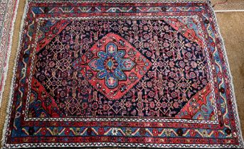 An old Persian Hamadan rug, the blue ground centered by a red ground medallion, 92 cm x 142 cm
