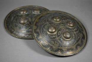 Two early 20th century Indo-Persian brass dhal shields, both of typical convex form with rolled