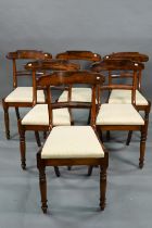 A set of six Victorian hardwood dining side chairs with shaped bar backs over fabric seat pads,