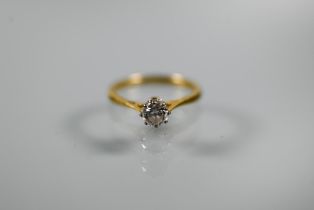 A single stone diamond ring, the brilliant cut diamond in coronet setting with scroll shoulders,