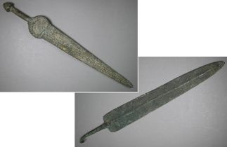 A Bronze Age sword, the tapering fullered blade with midrib, extending from oval shoulder, with