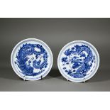 A pair of Chinese blue and white circular stands or dishes, painted in underglaze blue with a dragon