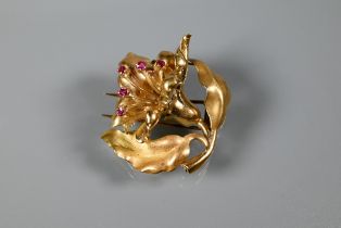 An Italian fur clip in the form of a naturalistic open flower with ruby-set stamen, stamped ORO 750,