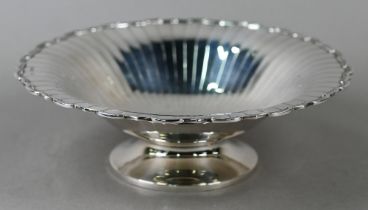 An Art Deco silver dish with radiating shallow flutes and moulded rim, on raised foot, Selfridge &
