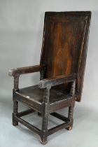 A Charles I jointed oak box-seat table-chair, circa 1640, having a pivotal boarded top/back with